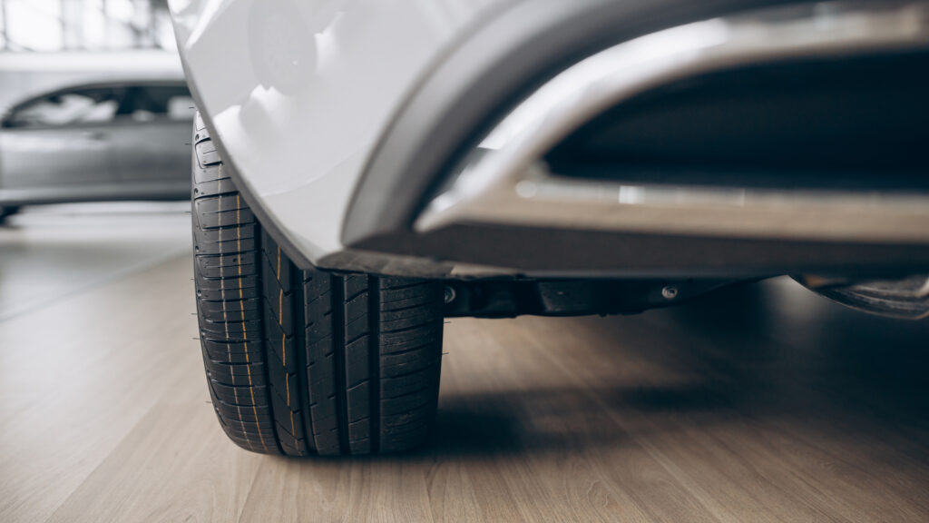 Pneu automotivo em foco do lado direito de um carro branco